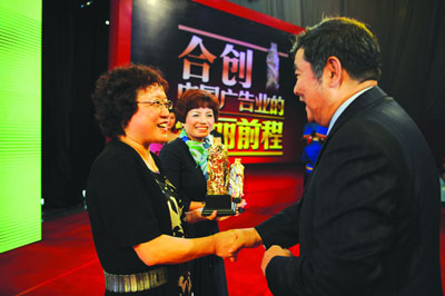 赵远花获得中国广告主长城奖功勋奖，中国广告协会会长李东生为她和同时获此殊荣的青岛啤酒全球营销总裁严旭（中）颁奖。